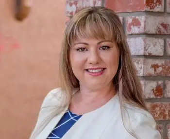 A woman with long hair and a blue tie.